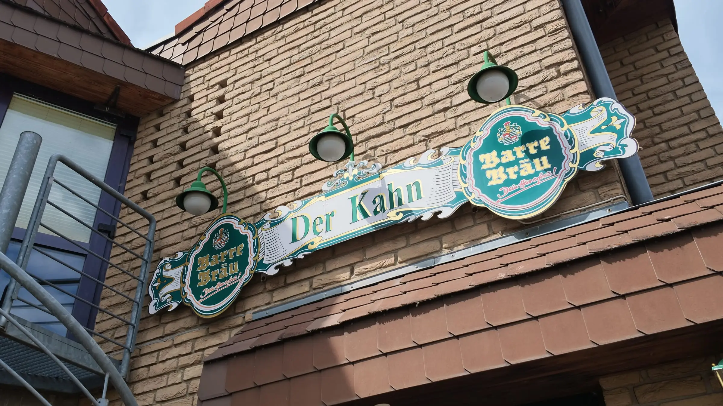 Das beleuchtete Schild „Der Kahn“ an der Klinkerfassade