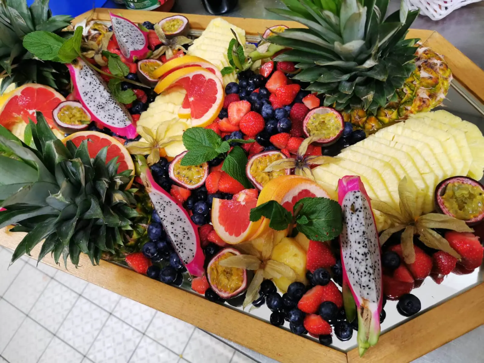 Üppige Obstplatte mit Ananaskronen und Grapefruitscheiben, garniert mit frischen Minzblättern